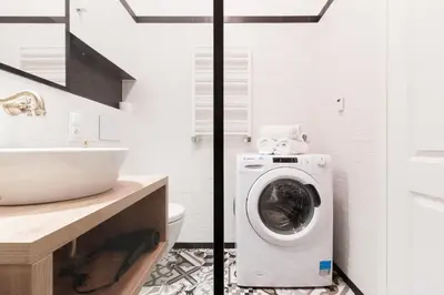 a bathroom with a washing machine and a sink at Prague Days - Art Deco Studio near Main Train Station in Prague