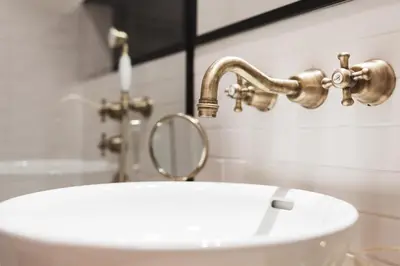 a bathroom with a white sink and a faucet at Prague Days - Art Deco Studio near Main Train Station in Prague