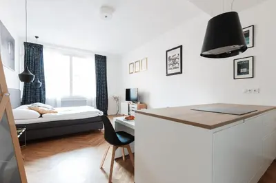 a bedroom with a bed and a desk with a chair at Prague Days - Art Deco Studio near Main Train Station in Prague