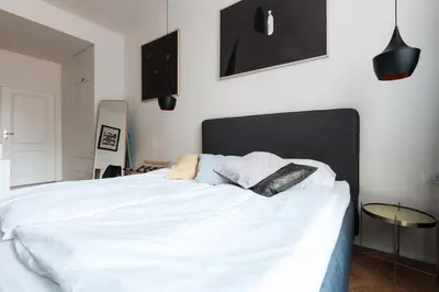 a bedroom with a large white bed with pillows at Prague Days - Art Deco Studio near Main Train Station in Prague