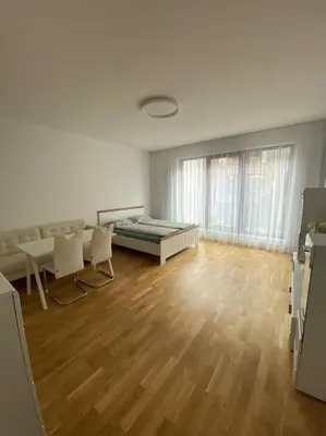 a room with a bed and chairs and a wooden floor at Quiet apartment near Prague centre in Prague