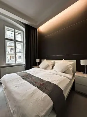 a bedroom with a large bed with a black wall at Château Étoile Loft - PRG Centre in Prague
