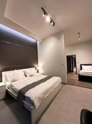 a bedroom with a large white bed with a black headboard at Château Étoile Loft - PRG Centre in Prague