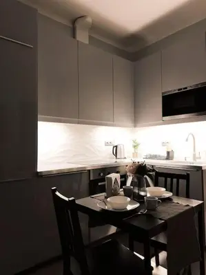 a kitchen with a table with chairs and a kitchen with white cabinets at Château Étoile Loft - PRG Centre in Prague