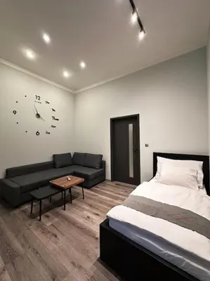 a bedroom with a bed and a couch and a clock at Château Étoile Loft - PRG Centre in Prague