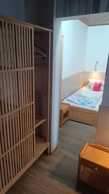 a small room with a bed and a closet at Hotel Kormoran in Zlenice
