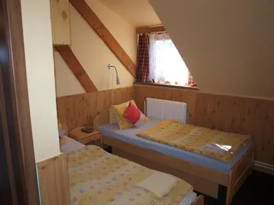 a small room with two beds and a window at Hotel Kormoran in Zlenice