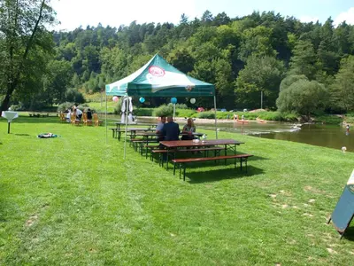 a group of people sitting at a picnic table under a tent at Hotel Kormoran in Zlenice