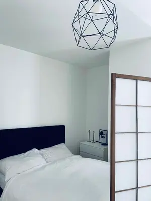 a bedroom with a bed and a blackendant light at Cozy apartment, close to city center of beautiful Prague in Prague