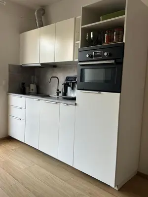 a kitchen with white cabinets and a black oven at Cozy apartment, close to city center of beautiful Prague in Prague