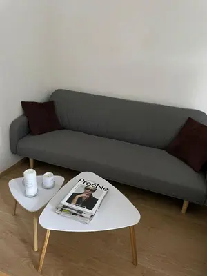 a couch with a magazine on a coffee table at Cozy apartment, close to city center of beautiful Prague in Prague