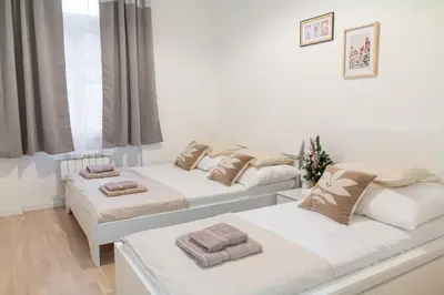 two beds in a room with white walls at Unique apartment by Wenceslas square in Prague