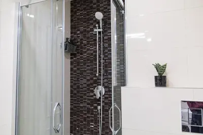 a shower in a bathroom with a brick wall at Unique apartment by Wenceslas square in Prague