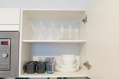 a cupboard filled with glasses and plates in a kitchen at Unique apartment by Wenceslas square in Prague
