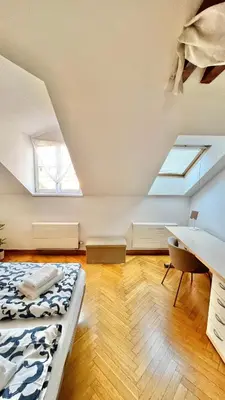 a attic bedroom with a bed and a desk at Miru Loft Prague in Prague
