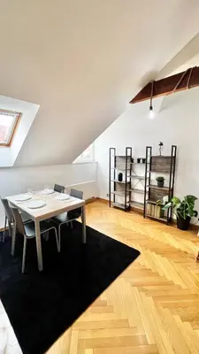 a dining room with a table and chairs on a rug at Miru Loft Prague in Prague