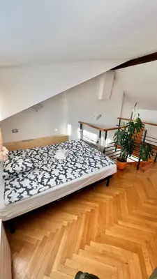 a large bed in a room with a wooden floor at Miru Loft Prague in Prague