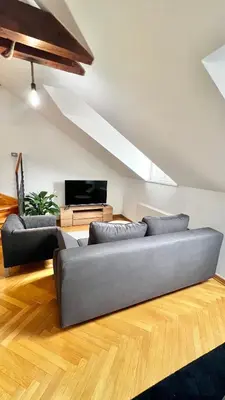 a living room with a couch and a tv at Miru Loft Prague in Prague