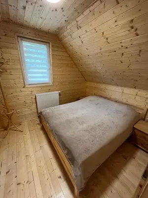 a bed in a wooden room with a window at Wellness House Prague Pohádkový Ráj in Prague