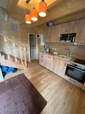 a large kitchen with wooden walls and wooden floors at Wellness House Prague Pohádkový Ráj in Prague
