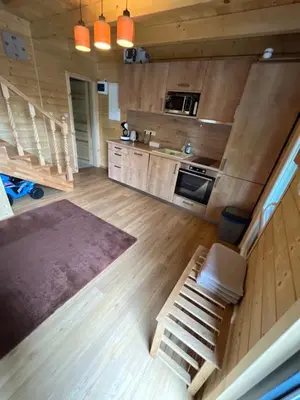 a kitchen with wooden walls and a staircase in a house at Wellness House Prague Pohádkový Ráj in Prague