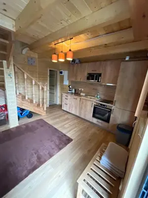 a large kitchen with wooden walls and wooden floors at Wellness House Prague Pohádkový Ráj in Prague