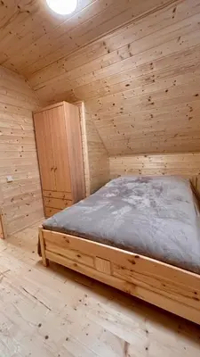 a wooden bedroom with a bed in a cabin at Wellness House Prague Pohádkový Ráj in Prague