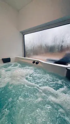 a bath tub with a large window in a bathroom at Wellness House Prague Pohádkový Ráj in Prague