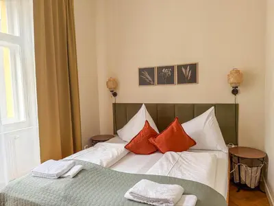 a bedroom with a bed with red and white pillows at Radost Residence The Heart of Unique Living in Prague
