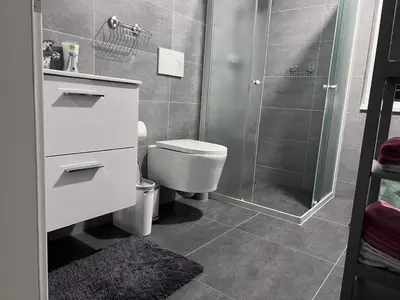 a bathroom with a toilet and a shower at Modern apartment close to Tram and Airport, free parking in Prague