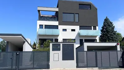 a house with a fence in front of it at Modern apartment close to Tram and Airport, free parking in Prague