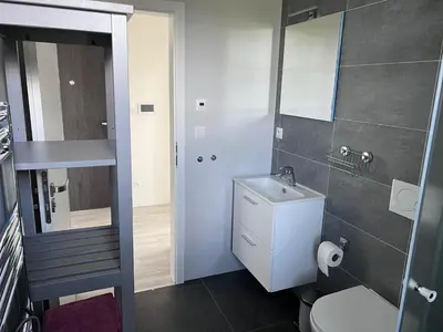 a bathroom with a sink and a toilet and a mirror at Modern apartment close to Tram and Airport, free parking in Prague