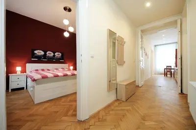 a bedroom with a bed with a red wall at Historic Centre Apartments V in Prague