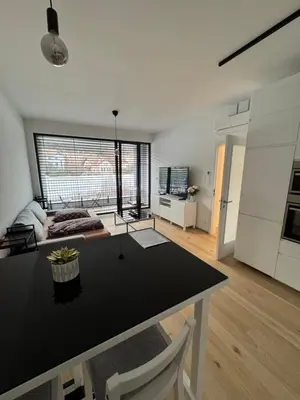 a kitchen and living room with a table in a room at Apartmán v nové rezidenci in Prague