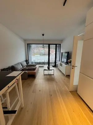 a living room with a couch and a large window at Apartmán v nové rezidenci in Prague