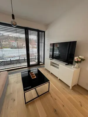 a living room with a couch and a tv at Apartmán v nové rezidenci in Prague