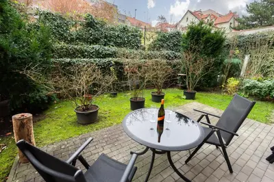 a table and chairs with a bottle of wine on it at Bliss Apartment in Prague