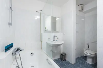 a bathroom with a tub and a sink and a toilet at Bliss Apartment in Prague