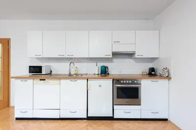 a kitchen with white cabinets and a counter top at Bliss Apartment in Prague