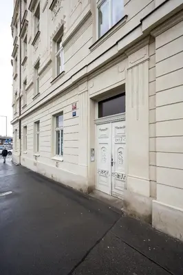 a white building with two garage doors on a street at Prague Days - Family-friendly Apartment with high speed Wi-Fi and Netflix in Prague