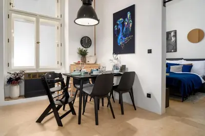 a dining room with a table and chairs and a bedroom at Prague Days - Family-friendly Apartment with high speed Wi-Fi and Netflix in Prague