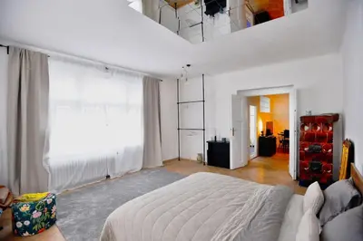 a white bedroom with a bed and a large window at Airy & Bright Flat in Dejvice by Prague Castle in Prague