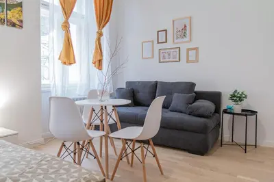 a living room with a couch and a table and chairs at Cozy Apartment by Wenceslas square in Prague