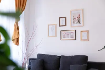 a living room with a blue couch and framed pictures at Cozy Apartment by Wenceslas square in Prague