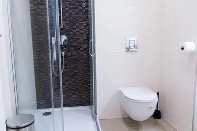 a bathroom with a toilet and a glass shower at Cozy Apartment by Wenceslas square in Prague