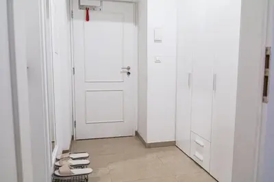 a hallway with white doors and a row of shoes at Cozy Apartment by Wenceslas square in Prague