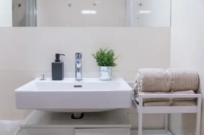 a bathroom with a white sink and a chair at Cozy Apartment by Wenceslas square in Prague