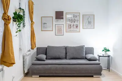a couch in a living room with pictures on the wall at Elegant Apartment in Wenceslas Square in Prague