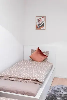 a bed in a white room with a pillow on it at Elegant Apartment in Wenceslas Square in Prague