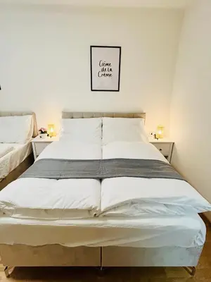 a large white bed in a bedroom with two night stands at New Luxury Apartmen at Andel Metro Station in Prague